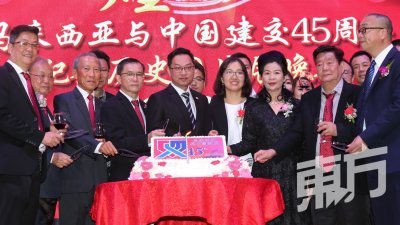 石声亮（左4起）、潘伟斯、王洁及王筠惠等人一同切蛋糕庆祝马中建交45周年。（摄影：刘维杰）