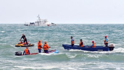 搜救人员乘坐游艇在直落比达乐海上搜寻4名坠海的学生踪影。