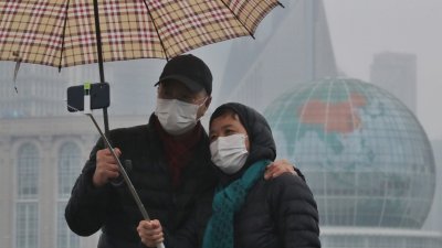 受新型冠状病毒感染的肺炎疫情影响，在上海外滩的游客纷纷戴上口罩出行。