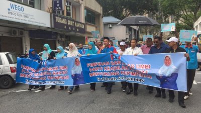 尽管下著细雨，但是声援祖莱达的代表依然缓缓步行至公正党霹雳州总部外，以进行和平请愿。