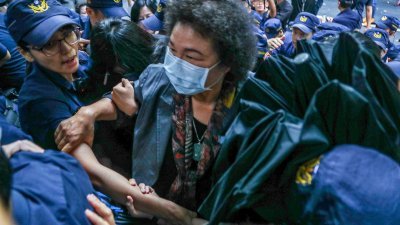 台湾立法院临时会周二将审查监察院长被提名人陈菊（中），当局出动大批警察维安，陈菊最终在蓝绿立委混战中突围进入议场。