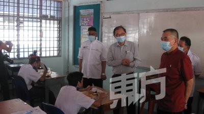 马汉顺（站者左2）巡视学校时，勉励学生积极应对新冠肺炎疫情。（视频：黄俊南）