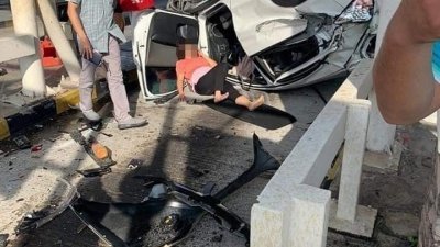 本田HRV轿车女司机在车祸后被公众抬出车外，等待救护车抵达现场。