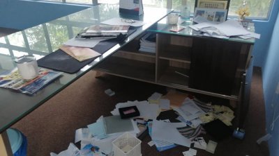 叶洹坝办公桌内的物件凌乱不堪，文件散落地上。