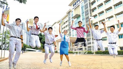 考获佳绩的学生在校门前跳跃欢呼，记录美好的一天。（摄影：曾钲勤）