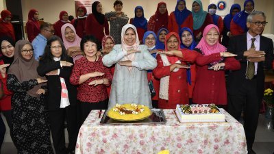 祖莱达（中）在马来西亚心脏基金会配合年国际妇女节所举办“爱护女性”活动上，一同比起活动的手式。
