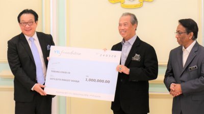 首相丹斯里慕尤丁（右2起）从杨肃斌手中，接领由杨忠礼基金会捐献的100万令吉模拟支票，以协助受新冠肺炎疫情影响的大马人民。
