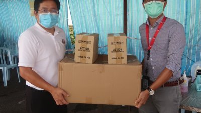 陈正春（左）派发1000片口罩及12支洁手液予昔加末政府医疗诊所，由卡斯尔接领。