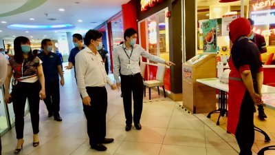 曹观友（左2）周五巡视商店恢复营业的状况。