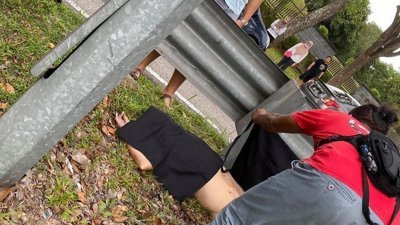 马来男子骑摩哆撞向路旁栏杆后当场死亡，民众以衣物遮盖死者的遗体。（图取自面子书）
