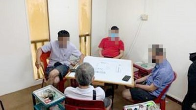 4名男子围坐在一起打麻将，遭新加坡警方检举。