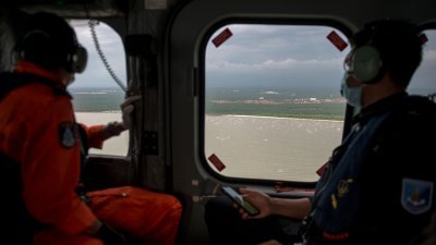 警方飞行部队警官波拉汉（左）与阿当阿都拉在马六甲海峡一带巡查，阻止非法入境者偷渡。