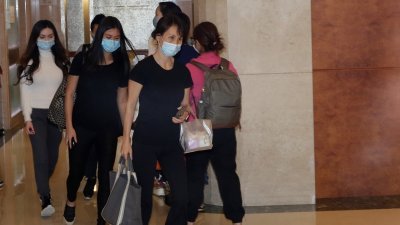 何超凤与两名女儿何倩珩以及何锶珩(白衣)离开医院。（图摄影自香港01）