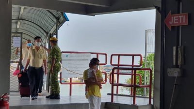巴生南港码头加强防疫措施，对进出码头的民众进行体温测量。