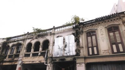 吉灵街其中一间属于马六甲宗教理事会（右）的空置老店屋单位无人打理，结构已破损。