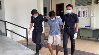 嫌犯（中）被警方押往峇株巴辖推事庭申请延扣，获准延扣至本月14日助查。