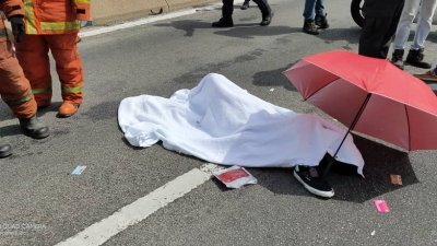 死者阿玛阿里夫命丧大桥，救护人员用白布遮盖其遗体。
