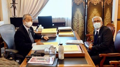 首相慕尤丁（左）在办公室，接见即将在12月5日荣休的阿布卡欣。