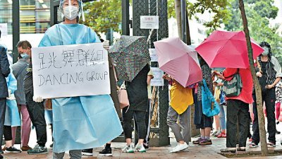 香港政府要求，曾到指定跳舞场所的人士，前往相关地点接受检疫。多个社区检测中心大排长龙，有民众更等候长达3小时，图为现场工作人员正拿著写有“跳舞群组”字眼的牌子。