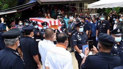 巴哈鲁丁的棺木盖上一面国旗，并以警队最高规格的仪式举办葬礼，场面一片哀伤。（马新社）