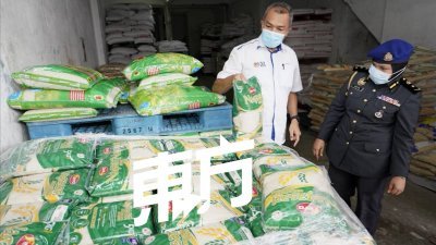 赛夫里占（左）检查旧街场一家批发商的白米货源，右为霹雳州贸消局副局长多蒂。