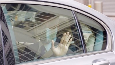 李显龙隔著车窗向守候在场的媒体挥手。