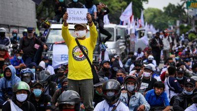 印尼贸易工会成员在雅加达的示威中，高举“反对新劳工法”的口号。（图取自路透社）