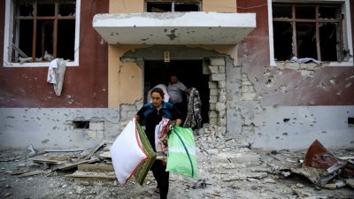 阿塞拜疆边境城镇泰尔泰尔的争议地区纳卡区，居民上周六趁该国和亚美尼亚停火协议生效后，将自身物品搬出遭战火破坏的住家。(路透社)
