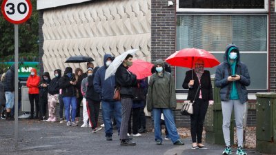 利物浦疫情居高不下，预计在新限制措施下将被列为最高风险城市。图为当地民众排队等待进行新冠病毒检测。-路透社-