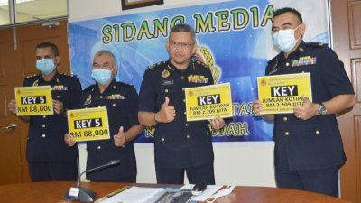 苏海米（左3）与官员展示“KEY”系列车牌的220万令吉收入及获得最高标价的“KEY 5”车牌号码。