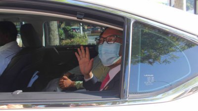 率先抵达霹州秘书署的阿末费沙，在大门处摇下车窗向媒体挥手问好。