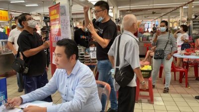 张哲敏（前）在金宝小食中心展开“挽救金宝山”签名运动，胡伟豪（后黑衣）率领马华党员到场呼吁民众支持响应。