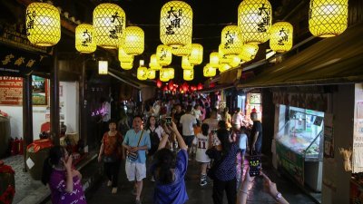 贵州省贵阳市花溪区青岩古镇景区举行的“夜间穿越游”活动，吸引众多游客前往参与。（图取自中新社）