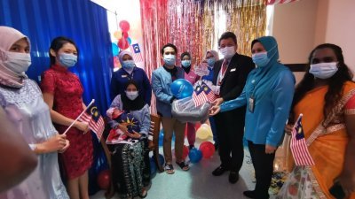 莫哈末阿兹哈（前排左5）代表柔佛医药保健集团专科医院，赠送婴儿汽车安全座椅予沙菲克（前排左4），为马来西亚日宝宝送上祝福。