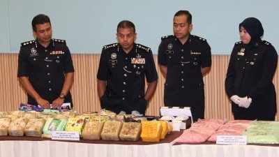 阿育甘（左2）展示警方起获的大批毒品。（摄影：刘维杰）