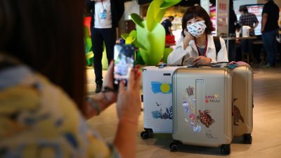 台湾和帕劳周四启动旅游泡泡，参与首发团的台湾旅客在桃园机场拍照，纪念这久违的时刻。（图取自路透社）