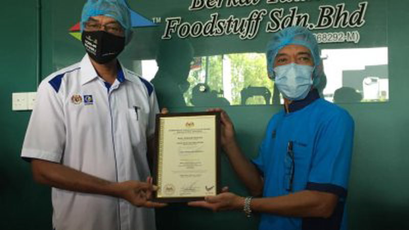 罗索华希（左）颁发“马来西亚制造”商标证书予阿占里。