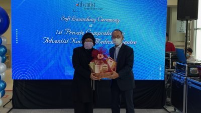 槟安医院首席执行员高华兴（右）在私人医院综合核医学中心预先推介礼上，移交纪念品给诺雷拉。