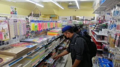 槟州贸消局执法官员细心审查商店内的所有商品。