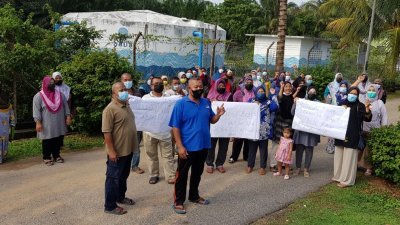 人民繁荣花园约40名居民走出屋外拉海报抗议，要求州政府为居民纾困，前左2为阿都拉曼。