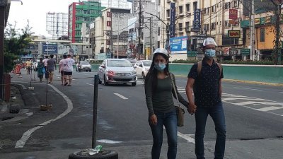 菲律宾疫情延烧，几乎每天都有上万人确诊，大马尼拉地区更是疫情重灾区，街头的民众也戴上口罩防疫。（图取自中央社）