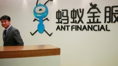 一名员工站在阿里巴巴金融分支机构蚂蚁金融服务集团徽标的旁边，其总部位于中国浙江省杭州市。