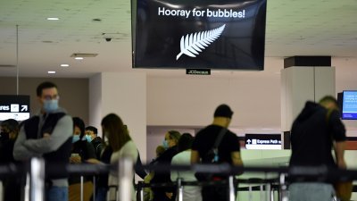 悉尼国际机场再次人声鼎沸，大批准备前往纽西兰的旅客等待办理登机手续，而上放的电子显示板打出代表纽西兰国家标志的银厥叶，还写著“为泡泡欢呼”。（图取自澳联社/路透社）