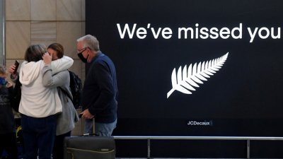 纽西兰和澳洲之间的“旅游泡泡”在过去的周一开启，纽西兰旅客飞抵悉尼国际机场，见到久违的亲友时激动相拥。（图取自澳联社/路透社）