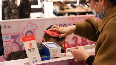 在上海新世界城，有消费者于3月8日国际妇女节使用“数字人民币”购买商品。这是“数字人民币”首次用于上海商场的营销活动中。（图取自中新社）