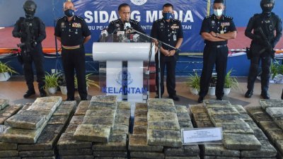 拉扎鲁丁（中）在记者会上，向媒体展示肃毒组在连续的突击行动中，起获的100公斤冰毒和393公斤的大麻，市值逾460万令吉。