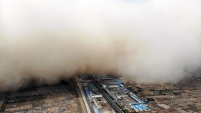 中国甘肃省张掖市临泽县境内，上周日（25日）遭遇沙尘暴袭击。这是中新社记者当天使用无人机，拍摄到“沙尘墙”滚滚推进画面。 （图取自中新社）