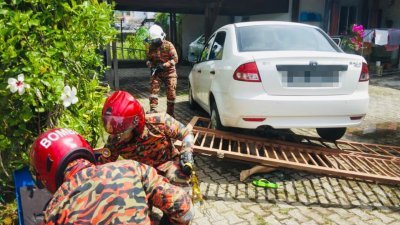 国产赛佳撞倒篱笆门，导致印尼籍女子惨遭紧压在赛佳及篱笆门下，大队的消拯人员刻正奋力施救中。
