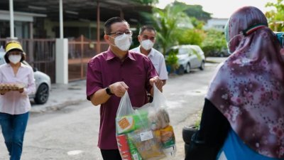 林冠英（左2）到峇眼国会选区内的6个甘榜分发650份食物援助给有需要的居民。