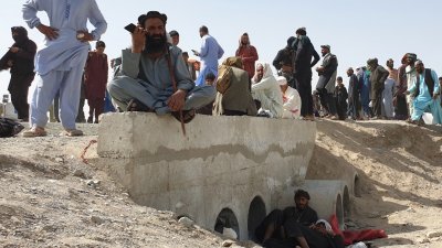 塔利班在全国范围进行的快速攻势中控制了阿富汗边境城镇，滞留的人们等待当局关闭的过境点重新开放。（图取自法新社）